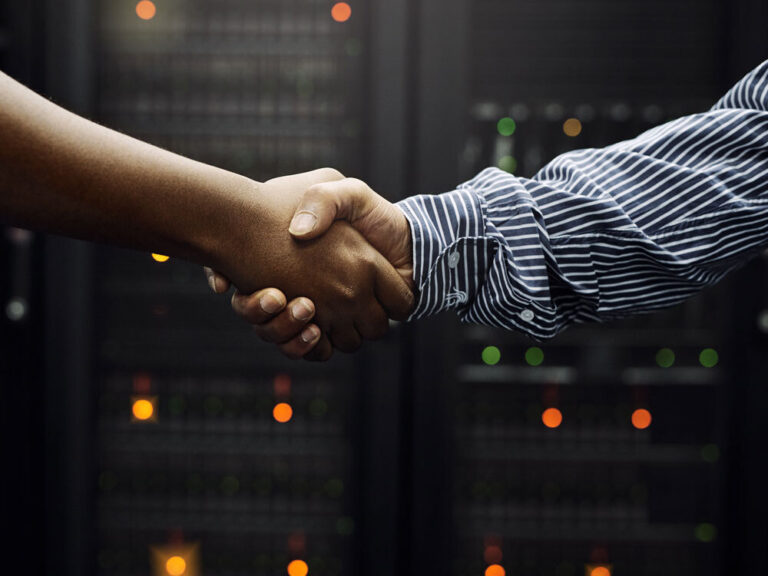 Why You Need a Turnkey Data Center Partner | Image of two arms shaking hands in front of server racks